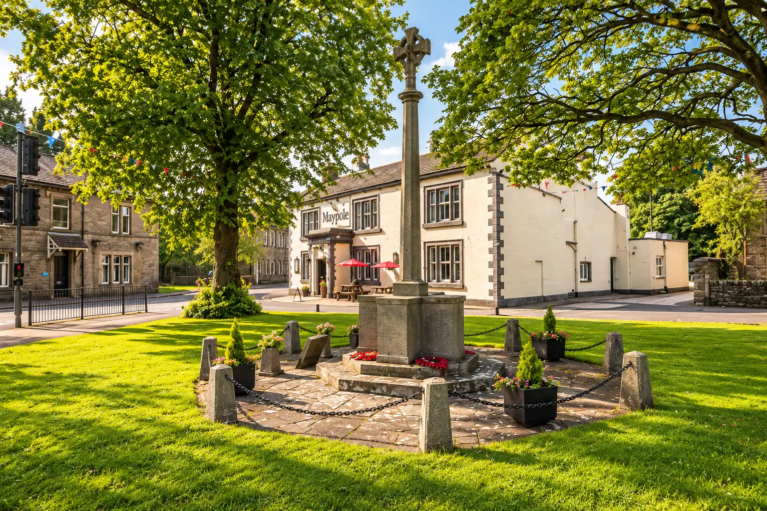 AI exterior illustration based on the Maypole Inn’s official current photograph: its cream-painted frontage, dark stone quoins, village-green war memorial, mature trees and red parasols. Not an actual photograph of the premises or visitors.